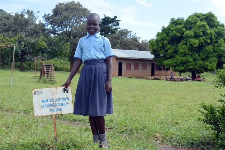 A child outdoors smiling in Africa
