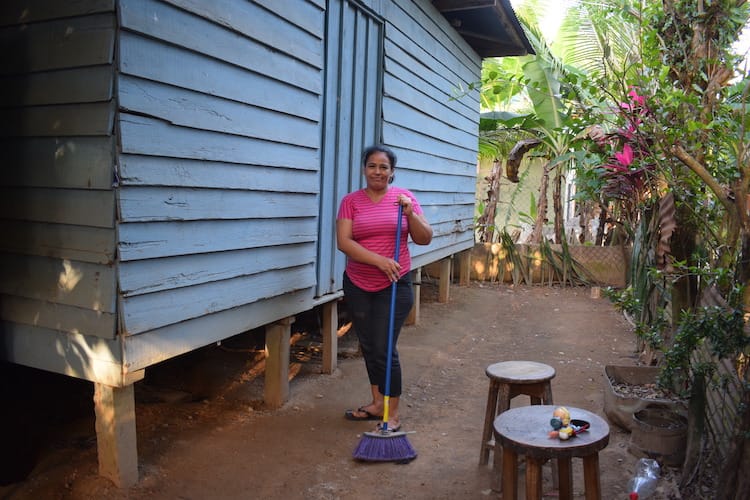 Una mujer barriendo con una escoba al aire libre